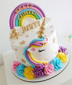 a birthday cake decorated with an unicorn and flowers