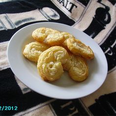 a white plate topped with cookies on top of a table next to a black and white blanket