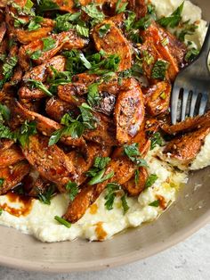 a plate filled with mashed potatoes topped with meat and garnished with parsley