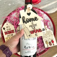 a bottle of wine is being held up by someone's hand with some tags attached to it