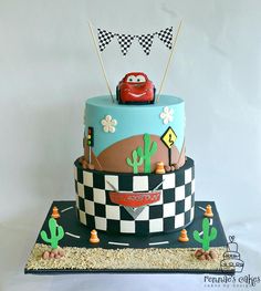 a birthday cake decorated with cars and flags