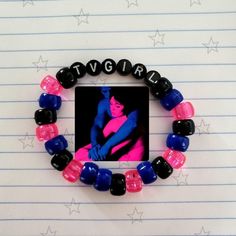 a bracelet made out of glass beads with a picture of a woman in pink and blue