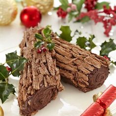 two pieces of food on a white plate with holly and red berries in the background