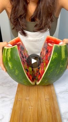 a woman is cutting up a watermelon with a knife