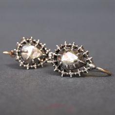 This dazzling pair of earrings date to the Georgian period (1714-1836). The tear-shaped drops feature spectacular rose cut diamonds with foil backing which sparkle vigorously as they catch the light. With a decorative silver border to complement the gems, collet settings and shepherd's crook fittings in 14ct yellow gold, it is rare to find earrings of this age in such wonderful condition. The fittings are stamped with partial hallmarks, but they are illegible. The gold tests as a minimum of 14ct. Weight (approximate): 2.8g Measurements (approximate): The drop length is 18mm. The diamonds measure 5mm x 5mm. Together, they have a weight of about 0.5 carats. Condition: Good, with wear commensurate with age. The diamonds have some small chips and natural inclusions visible when viewed under ma Rose Cut Diamond, Teardrop Earrings, Rose Cut, Jewelry Earrings Dangle, Diamond Earrings, Georgia, Dangle Drop Earrings, Dangle Earrings, Etsy Accessories