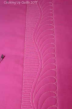 a close up of a pink piece of cloth with stitching on it and a sewing needle next to it