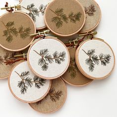 six embroidered hoops with pine needles on them