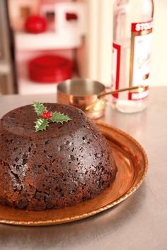 a chocolate cake sitting on top of a wooden plate next to a bottle of booze