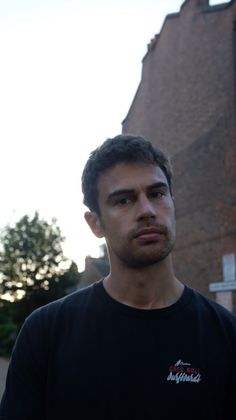 a man standing in front of a brick building