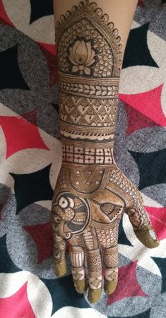 a henna tattoo on the hand of a woman's left arm and foot