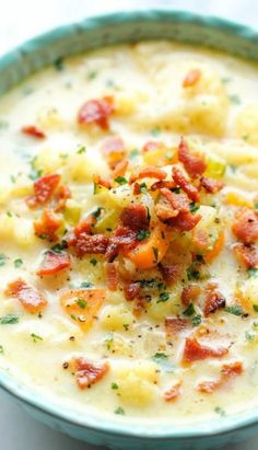 a blue bowl filled with potato soup on top of a table