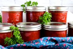 several jars filled with red sauce and parsley