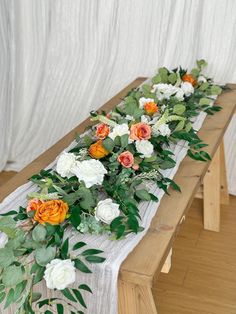 a long table with flowers and greenery on it