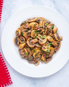 a white plate topped with mushrooms covered in sauce