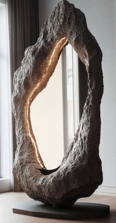 a large rock sculpture sitting on top of a wooden table in front of a window