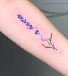 a purple flower tattoo on the arm