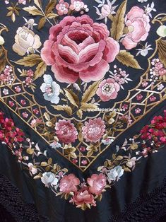 an embroidered table cloth with pink flowers and leaves on black lace, in the shape of a heart