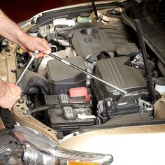 a man is working on the engine of a car