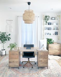 a room with a rug, desk and shelves on the wall next to a window