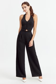 A stunning two-piece set in one! This jumpsuit resembles a chic vest set with a halter neck and comfortable elastic backing. Jumpsuit Halter neck Wide leg pants Lined Bodice Length: 17 1/2" Inseam: 29 7/8" Chest: 16 1/4" Waist: 14" Self: 100% Polyester Lining: 97% Polyester, 3% Spandex Hand wash cold with similar colors. Do not tumble dry, iron, or dry clean. Model is wearing a size S Style #: F242P6409 Black Halter Jumpsuit, Vest Set, Short Loungewear, Halter Jumpsuit, Swimwear Sale, Bottom Clothes, Ladies Boutique, Halter Neck, Sweater Jacket