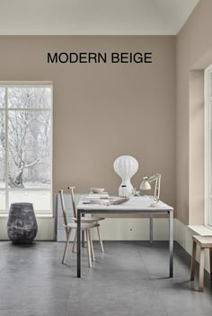 an empty room with a table and chairs in front of a window that reads modern beige