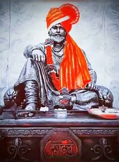 a statue of a man with an orange turban sitting on top of a table