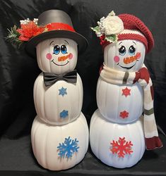 two snowmen with hats and scarves on their heads