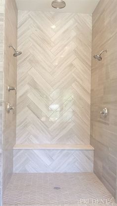 a bathroom with white tile and herringbone pattern on the shower wall, along with a bench