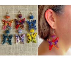 the earrings are made out of multicolored paper and have butterfly shaped beads on them