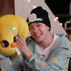 a young man holding up a stuffed animal