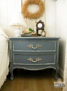 a blue dresser with a clock and wreath on top