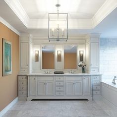 a large bathroom with double sinks and two mirrors on the wall next to a bathtub