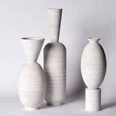 three white vases sitting next to each other