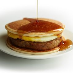 a stack of pancakes with syrup being drizzled on top