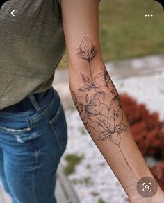 a woman's arm with a flower tattoo on the left side of her arm