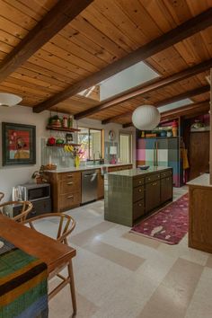 an open kitchen and dining room with wood ceiling