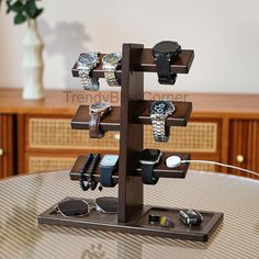 a wooden stand with several watches on it and two bracelets hanging from the top