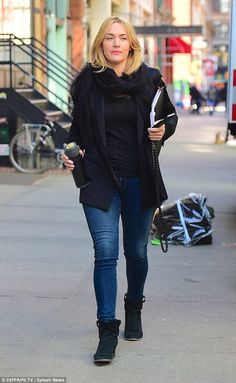 a woman is walking down the street with her cell phone