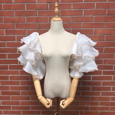 a mannequin wearing a white top with ruffles