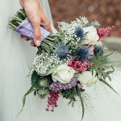 a person holding a bouquet of flowers in their hand