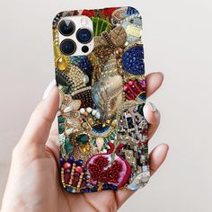 a person holding up a phone case with many different things on the back and sides