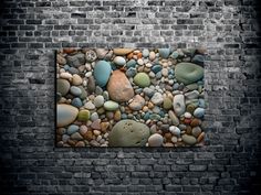 a brick wall with rocks and pebbles on it in front of a black brick wall