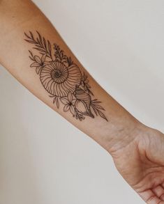 a woman's arm with a flower tattoo on it