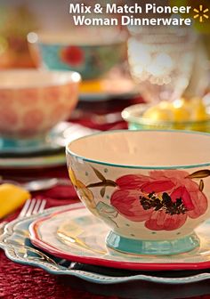 a close up of a cup and saucer on a table with other place settings