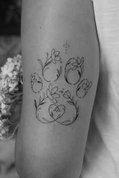 a black and white photo of a woman's thigh with flowers on it,