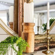 a mirror sitting on top of a table next to a candle holder and potted plant