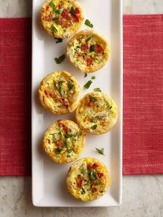 mini quiches on a plate with garnishes and parmesan cheese