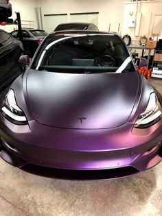 a purple car parked in a garage next to other cars