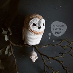 a crocheted owl sitting on top of a tree branch with a thought bubble above it