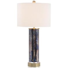 a blue and gold lamp with a white shade on the top, against a white background